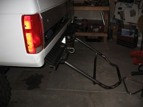 1995 Ford Bronco - Rear view of a white 1995 Ford Bronco showing a custom frame-mounted drop-down tire carrier.