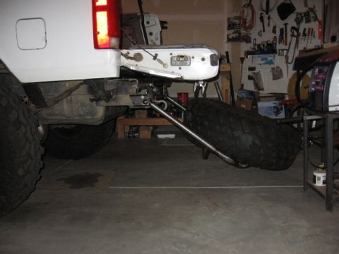 1995 Ford Bronco - Rear view of a white Ford Bronco showing a custom swing-away tire carrier mounted below the bumper.