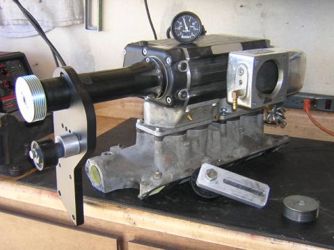 1993 Ford F-150 - A supercharger assembly, complete with a boost gauge, is shown on a workbench, suggesting an aftermarket performance upgrade.
