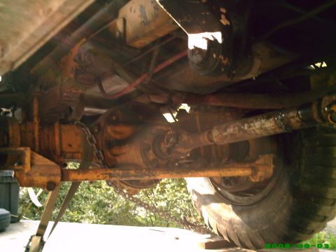 1978 Ford Bronco - Undercarriage view of a vehicle's rear axle, driveshaft, and tire.