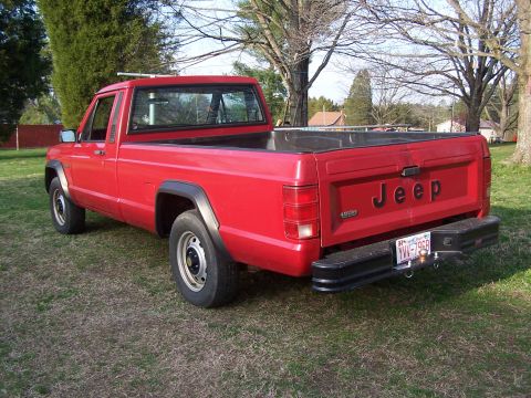 1991 Jeep Comanche - Rear view of a red 1991 Jeep Comanche pickup truck parked on grass.