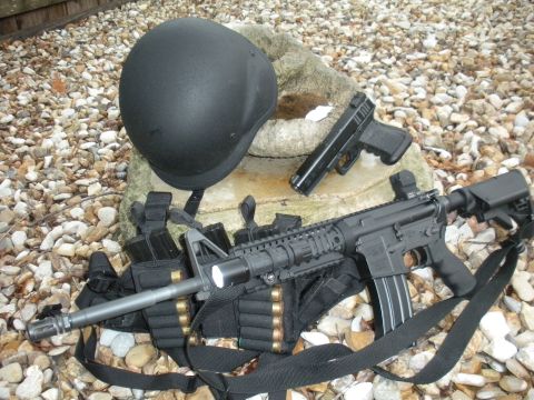1996 Ford Bronco - Tactical gear including a helmet, rifle, pistol, and ammunition is displayed on a gravel surface.