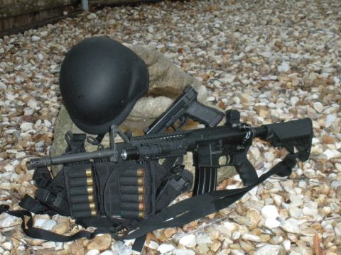 1996 Ford Bronco - A collection of tactical gear, including firearms and a helmet, is laid out on a bed of gravel.