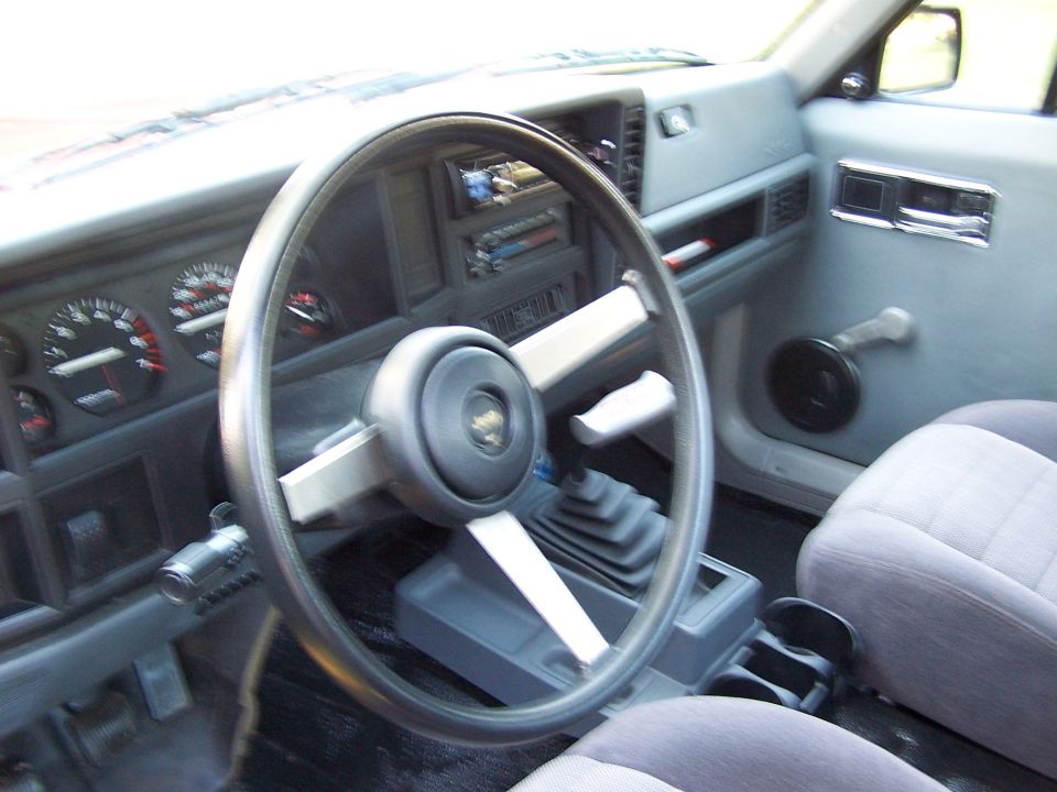 1991 Jeep Comanche interior showing dashboard, steering wheel, gear shifter, and passenger seat