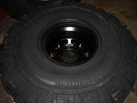 1979 Ford F-150 - A close-up view of a single off-road tire and its black rim, with chalk markings on the sidewall.