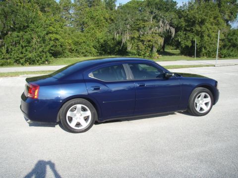 2006 Dodge Charger - A blue 2006 Dodge Charger is parked on an asphalt surface with trees in the background.
