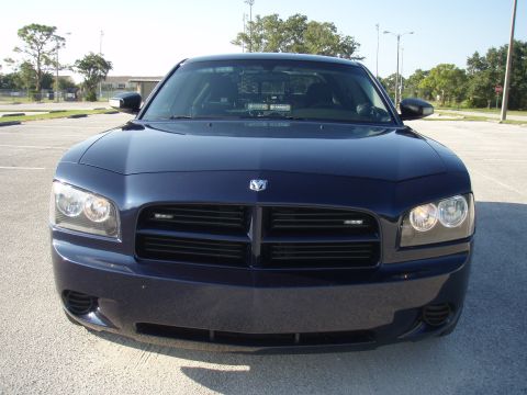 2006 Dodge Charger - Front view of a dark blue 2006 Dodge Charger, equipped with police lights and a partition visible through the windows.