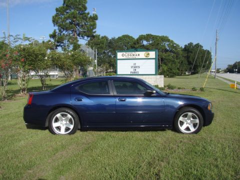 2006 Dodge Charger - A blue 2006 Dodge Charger is parked on a grassy area in front of a sign for Oldsmar.