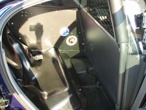 2006 Dodge Charger - The interior of a vehicle shows a partition and cage, suggesting it's a specialized vehicle like a police car.