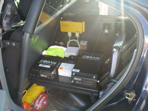2006 Dodge Charger - Interior view of a vehicle's cargo area, filled with various electronic devices and safety equipment.