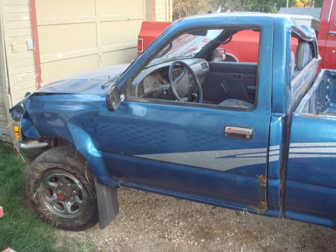 1991 Toyota Tacoma - This blue 1991 Toyota Tacoma pickup truck shows significant damage to its front fender and windshield.