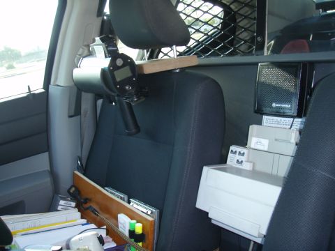 2006 Dodge Charger - This image shows the interior of a police vehicle, equipped with a radar gun and a Motorola radio unit.
