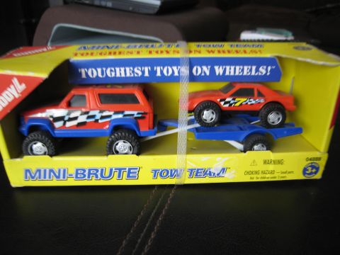 1986 Ford Bronco - This toy set features a Bronco-like vehicle and a sports car on a trailer, packaged for sale.