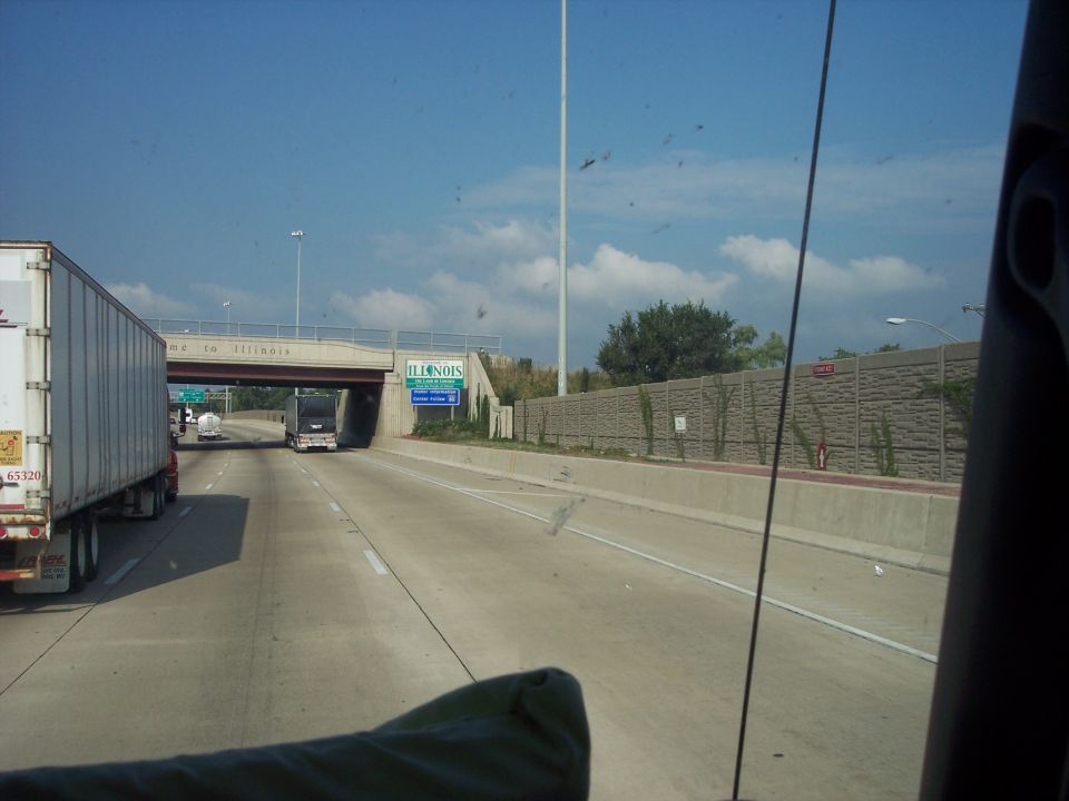 View through a windshield of an interstate passing a semi at the Illinois state line