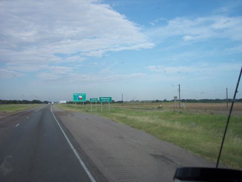1960 Ford Falcon - Roadside signs indicate the direction to Wheeler, Texas, under a partly cloudy sky.