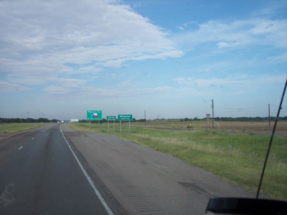 Welcome to Texas state line and Wheeler County road signs seen through a windshield