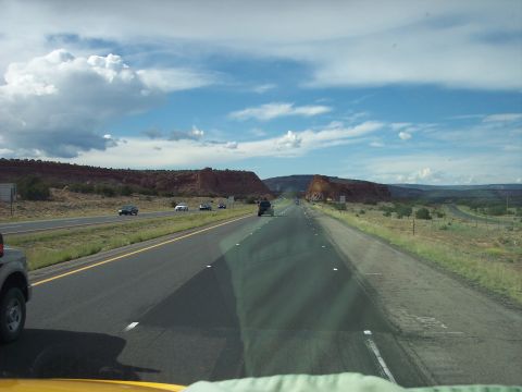 1960 Ford Falcon - Driving on a highway through a desert landscape with red rock formations and other vehicles.