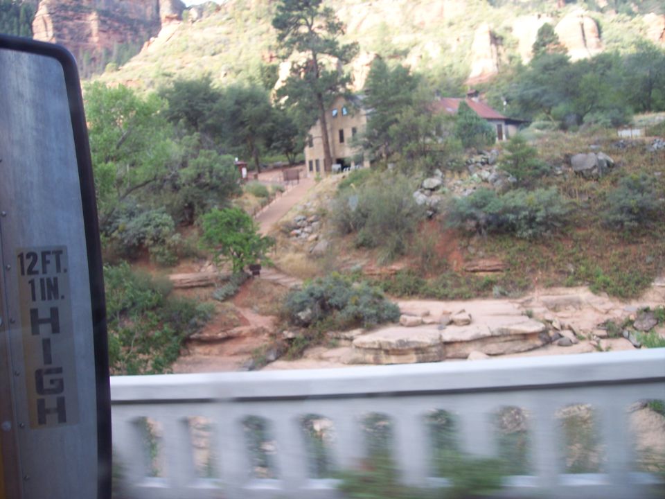 View of buildings on a hillside with mountains in background. Side mirror with height restriction visible