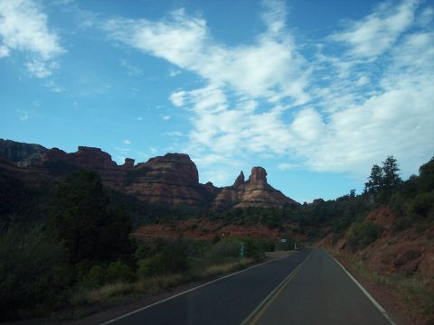 1960 Ford Falcon - A scenic drive winds through the iconic red rock landscape of Sedona, Arizona, under a bright, cloudy sky.