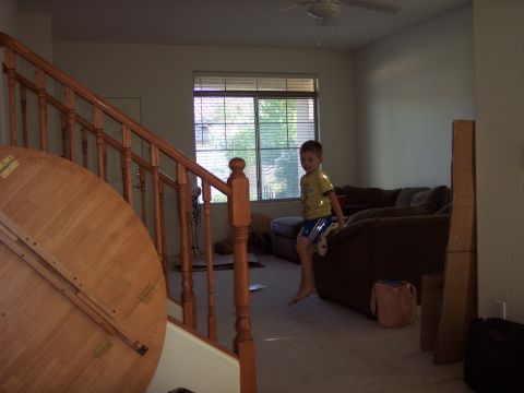 1960 Ford Falcon - A young boy sits on a couch in a room with a staircase and a window.