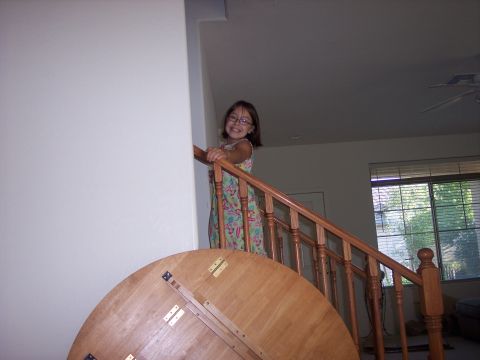 1960 Ford Falcon - A young girl stands on a staircase, holding the railing and smiling at the camera.