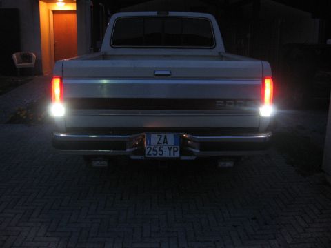 1990 Ford F-150 - The rear of a Ford F-150 pickup truck is shown at night, with its tail lights illuminated.