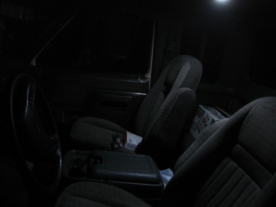 Interior view of a dark vehicle cabin with cloth seats and a center console