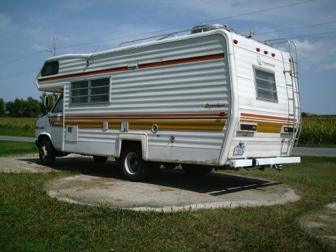 2001 Dodge 2500 - This motorhome features a classic design with horizontal siding and prominent striping along its side.