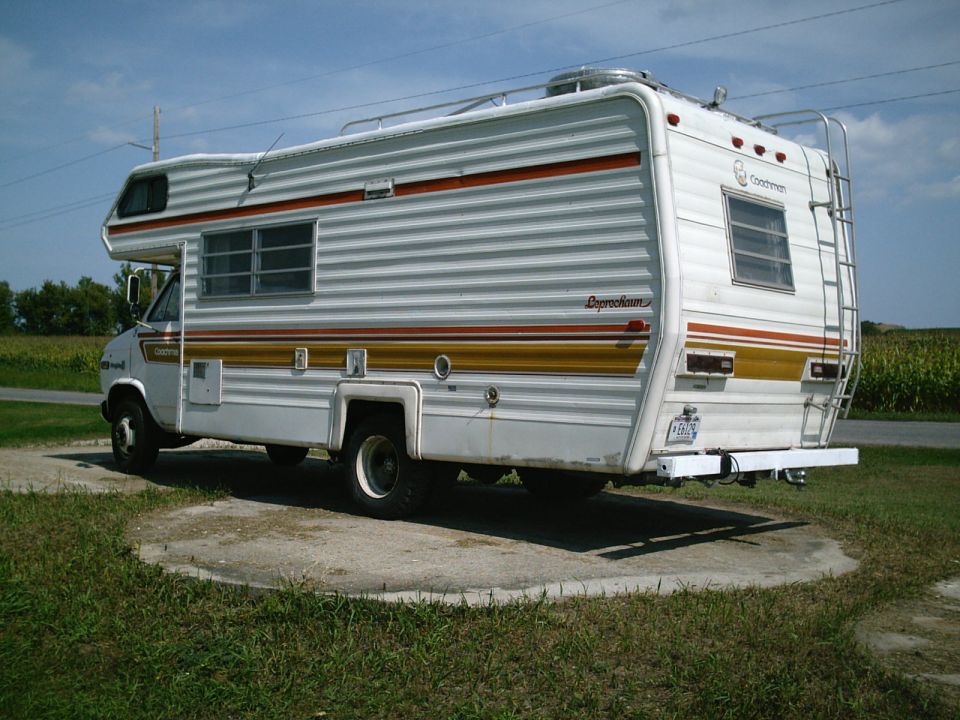 White motorhome with orange and gold stripes, side view
