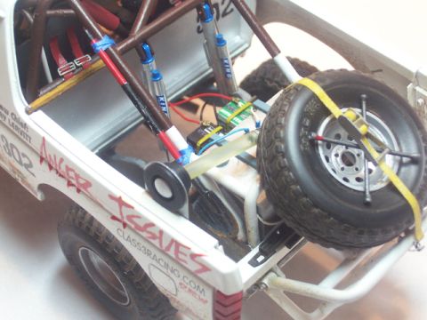 1986 Ford Bronco - Close-up view of a detailed model vehicle's interior, a spare tire and racing modifications.