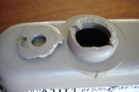 2006 Ford Fusion - Close-up of damaged plastic mounting hardware, showing torn edges around the holes.