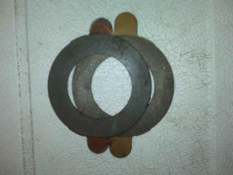1995 Ford Bronco - A collection of washers and shims, possibly for a differential build, are laid out on a textured surface.