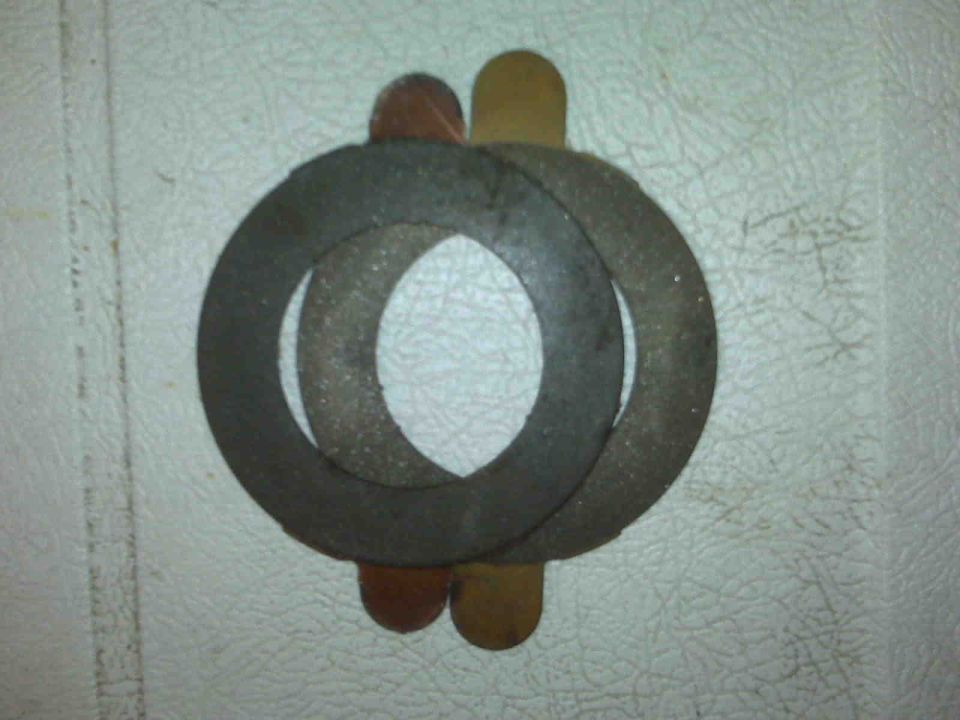 Stack of metal washers and shims with brown and tan tabs