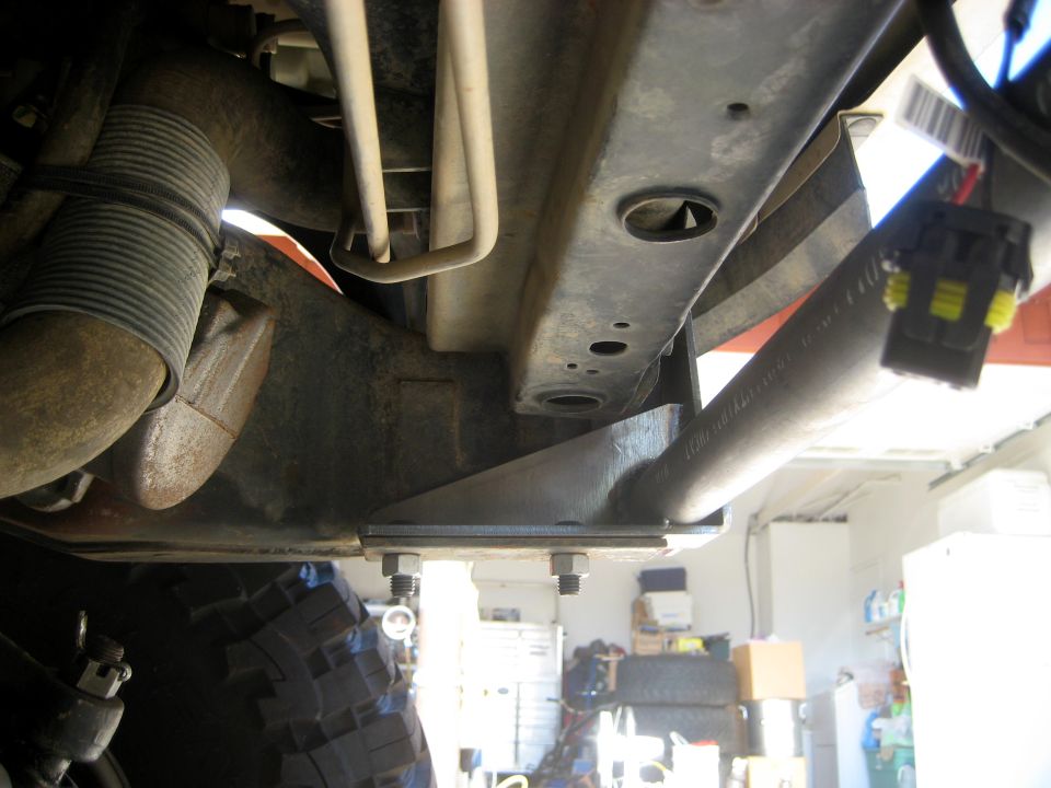 Underside of a vehicle's frame with suspension parts and a tire visible