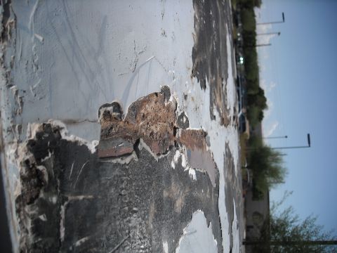 1990 Ford C-150 (Centurion Conversions) - Detail of severe corrosion and material degradation on an unidentified surface.