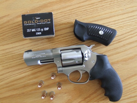 2002 Jeep TJ - A revolver, ammunition, and an extra grip are laid out on a wooden surface.