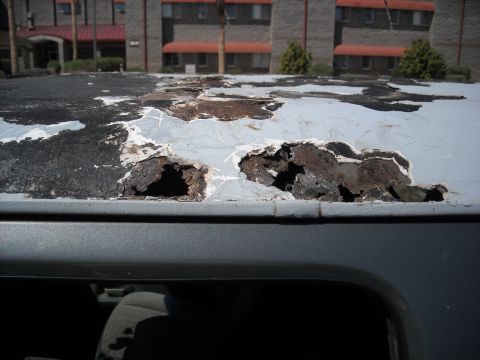 1990 Ford C-150 (Centurion Conversions) - Extensive rust damage is visible on the roof of a gray vehicle.