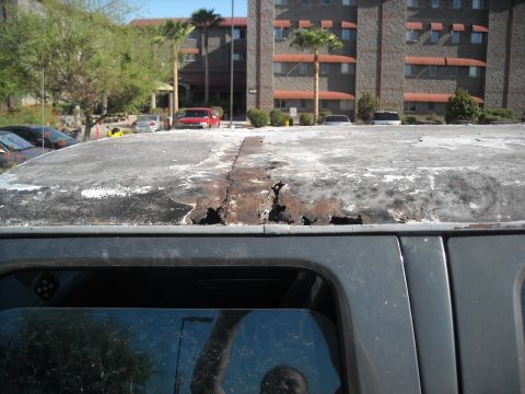 1990 Ford C-150 (Centurion Conversions) - The roof of a vehicle displays significant rust damage and deterioration.