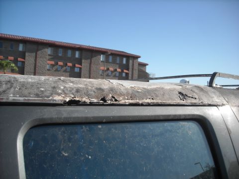 1990 Ford C-150 (Centurion Conversions) - The roof edge of a vehicle displays significant corrosion and damage.