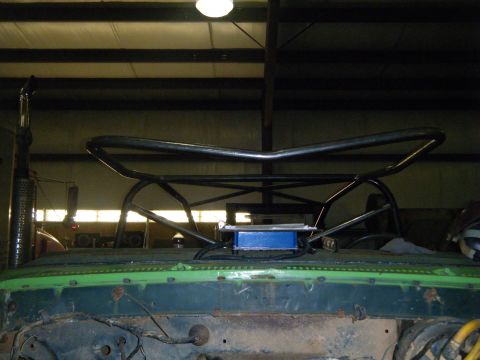 1978 Ford Bronco - Custom roll cage structure on a green vehicle's roof, with exhaust pipe visible.