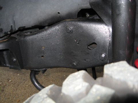 1990 Ford Bronco - This image shows a close-up view of a vehicle's undercarriage, focusing on the frame and a tire.