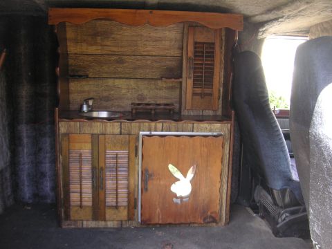 1979 Ford F-250 - This van features a custom wooden kitchenette with a sink and a unique Playboy bunny emblem on one of the cabinet doors.