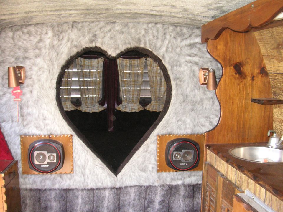 Van interior with heart-shaped window, faux fur lining, Sony speakers, and a sink