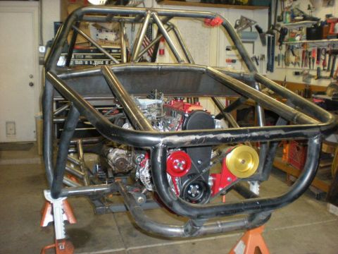 Suzuki Samurai - This custom buggy is in a garage, with its engine and roll cage clearly visible.
