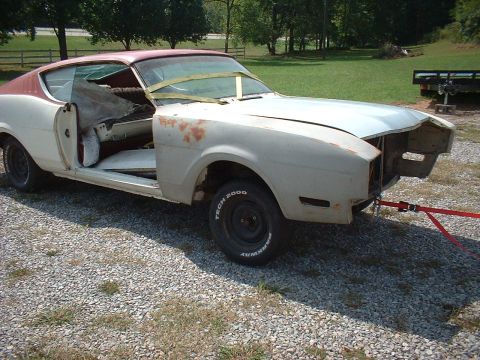 1969 Mercury Cyclone - This car is in a state of disrepair, with its doors off and interior visible, being towed by red straps.