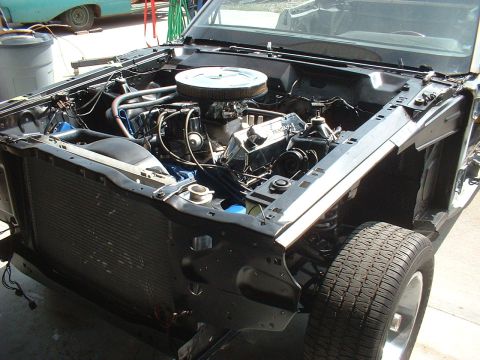 1970 Ford Torino - The engine compartment of a car is shown, with the V8 engine and radiator exposed.