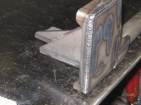 1996 Ford Bronco - A fabricated metal component with distinct weld beads is shown on a workbench.