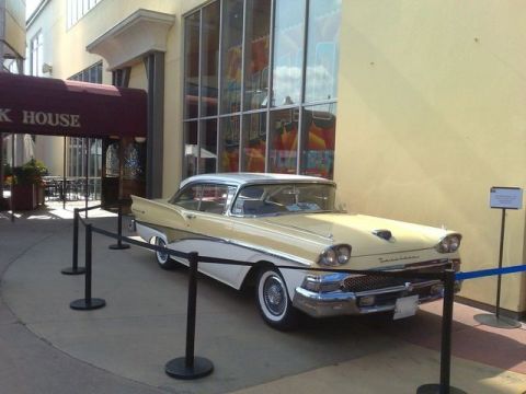 1991 Ford LTD Crown Victoria - Two-tone 1957 Ford Fairlane 500 parked outside a building with a red awning.