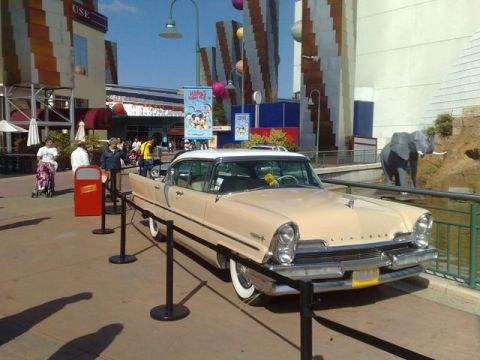 1991 Ford LTD Crown Victoria - This vintage Lincoln sedan is on display in an outdoor area with themed architecture and a large elephant statue.