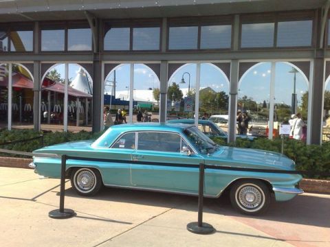 1991 Ford LTD Crown Victoria - Teal 1961 Oldsmobile Dynamic 88 coupe parked outside a building with arched windows and another car behind it.